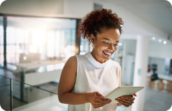 Empreendedora segurando um tablet sorrindo, confiando solução de Split de Pagamento da Cielo.